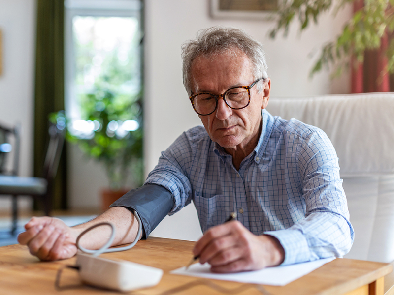 A man using a blood pressure monitor at home