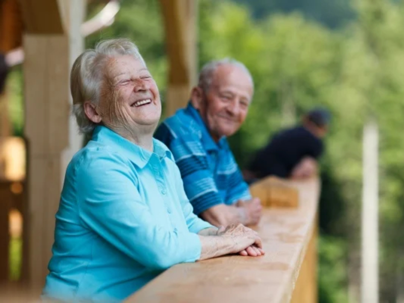 Two elderly people smiling outdoors