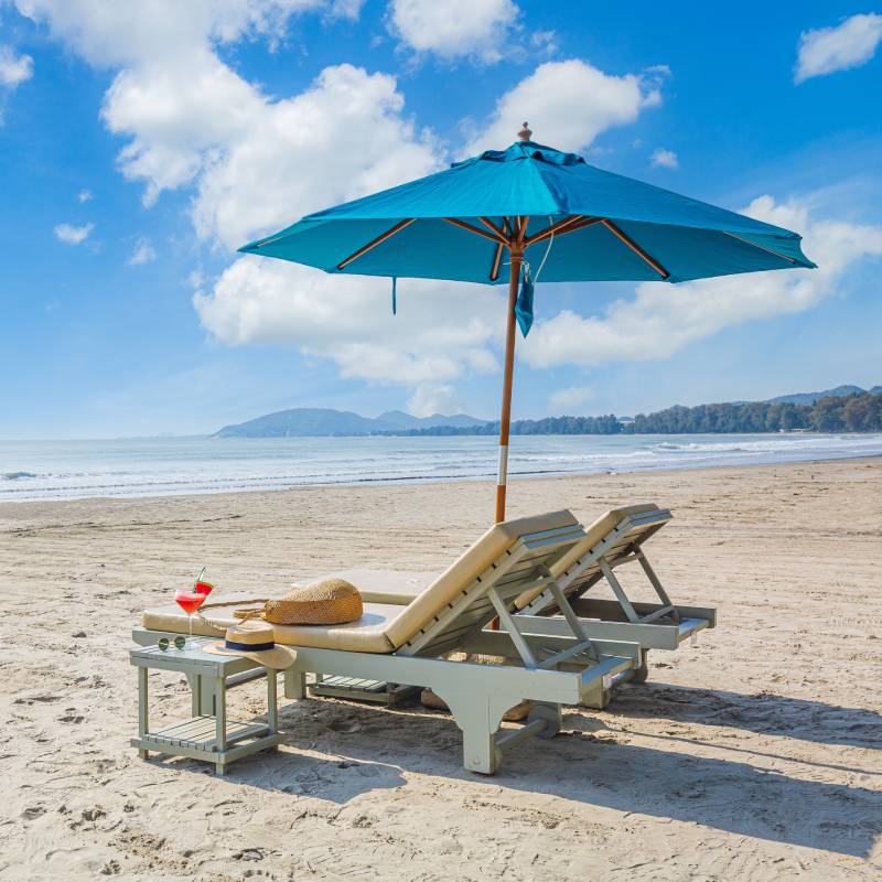 2 sun loungers and an umbrella on a white sand beach