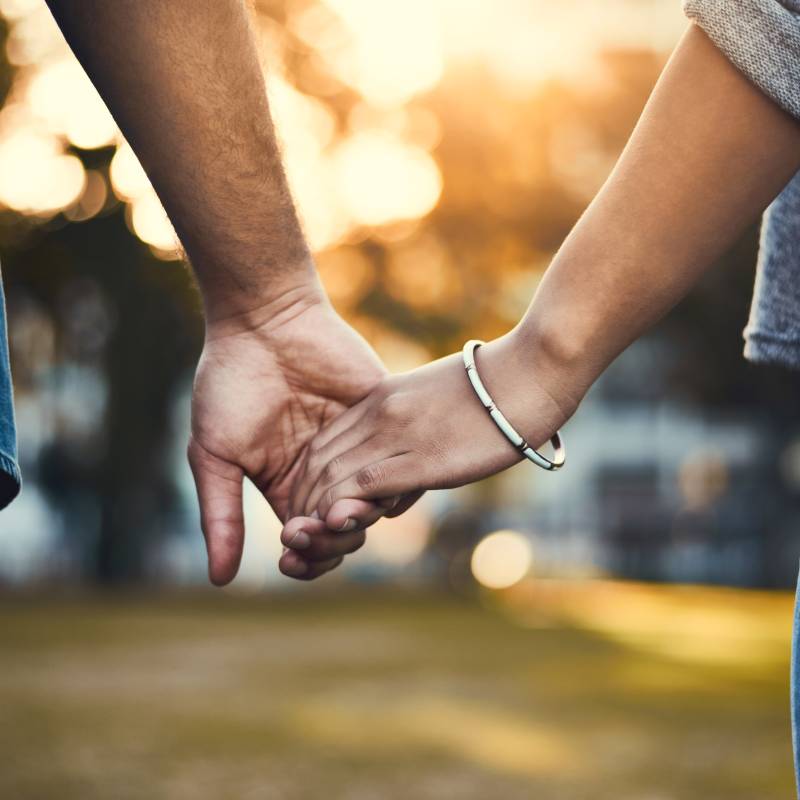 Two people holding hands outdoors
