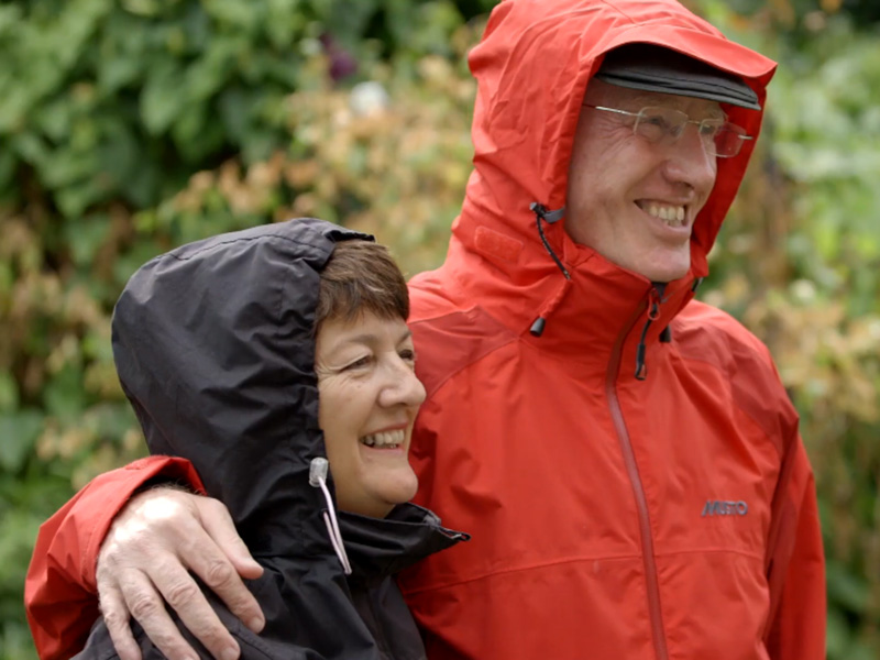 Sue hugging her husband walking on a rainy day