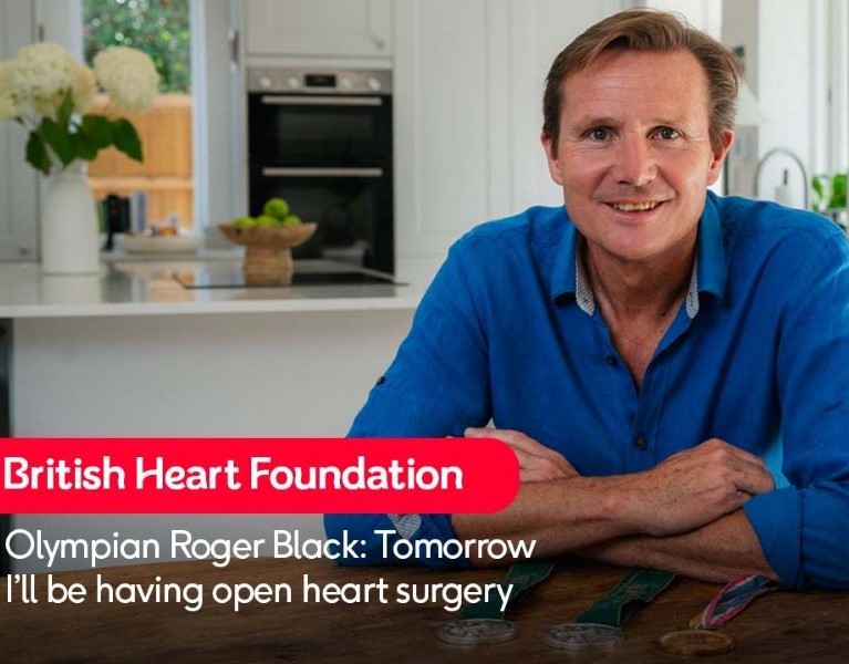 British Olympian Roger Black sits at his kitchen table with three of his athletics medals .