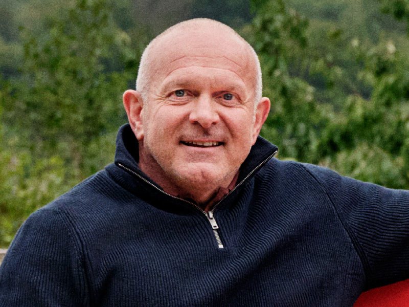 Dean sat on a red bench smiling