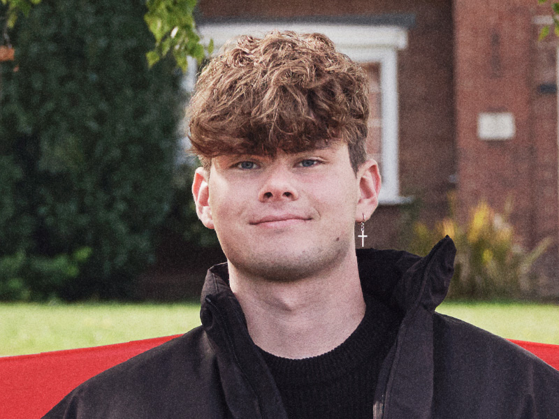 Jack sat on a red bench smiling