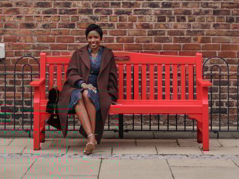 Michelle sat on a red bench smiling