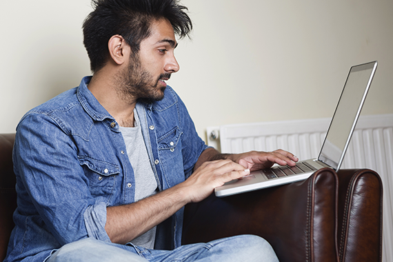 A man accesses the British Heart Foundation online community using his laptop