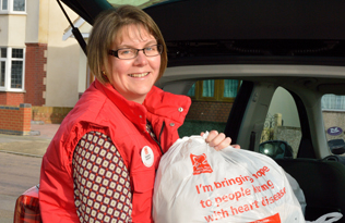 volunteer putting bags of donated items into her car
