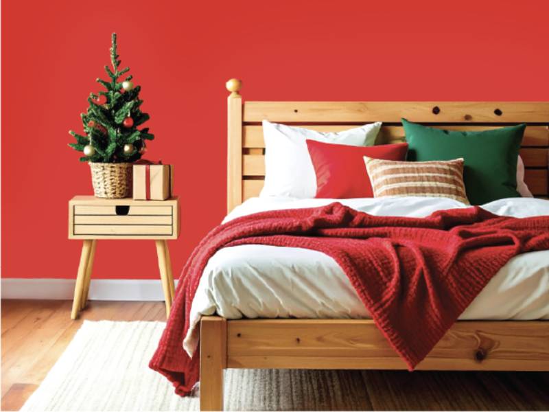A double bed and side table decorated for Christmas