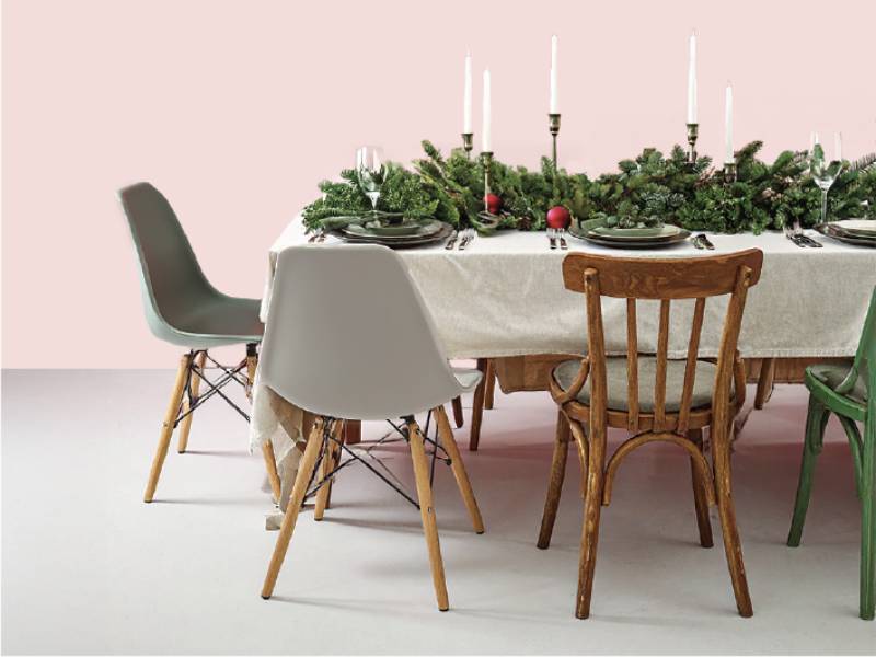 A dining table set up with candles and Christmas decorations