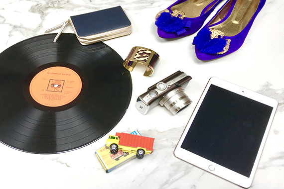 Assortment of donated items including shoes, records, jewellery, camera