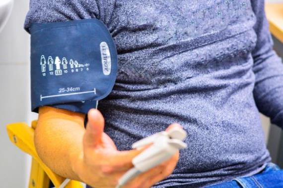 Man sat in a chair getting a high blood pressure reading