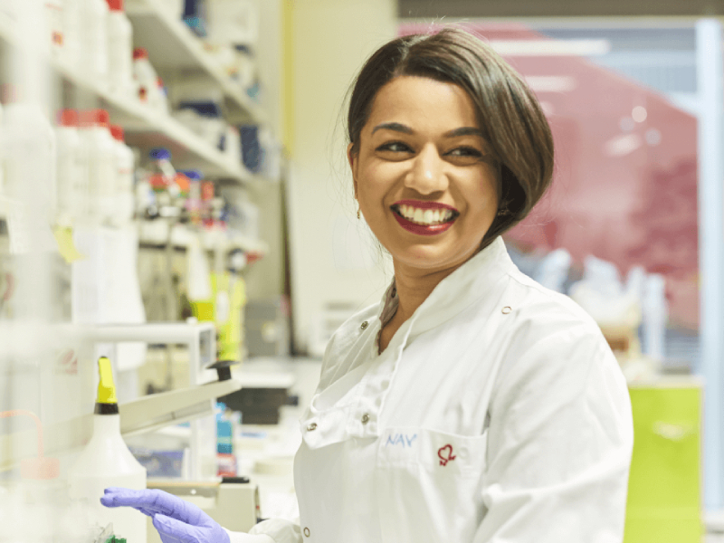A laboratory researcher smiling