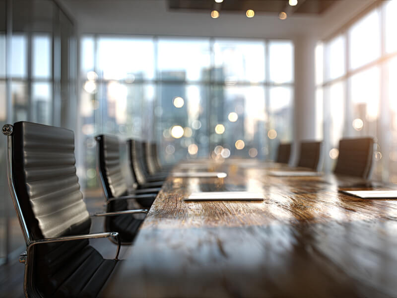 Conference room with empty black office chairs around a wooden table