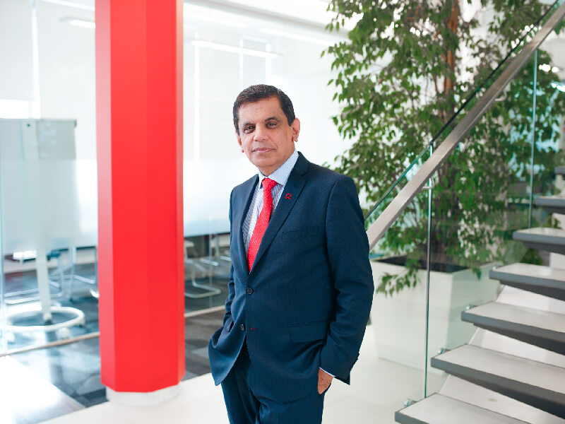 BHF Researcher wearing a suit stands at the bottom of a staircase