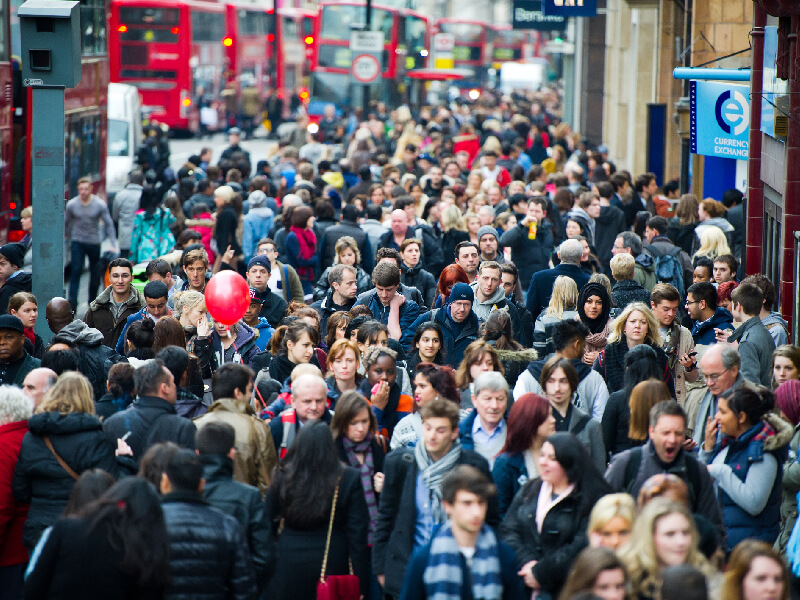 Large group of people walking on a street in London