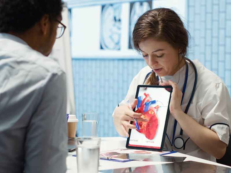 GP showing a patient an image of a heart on an iPad