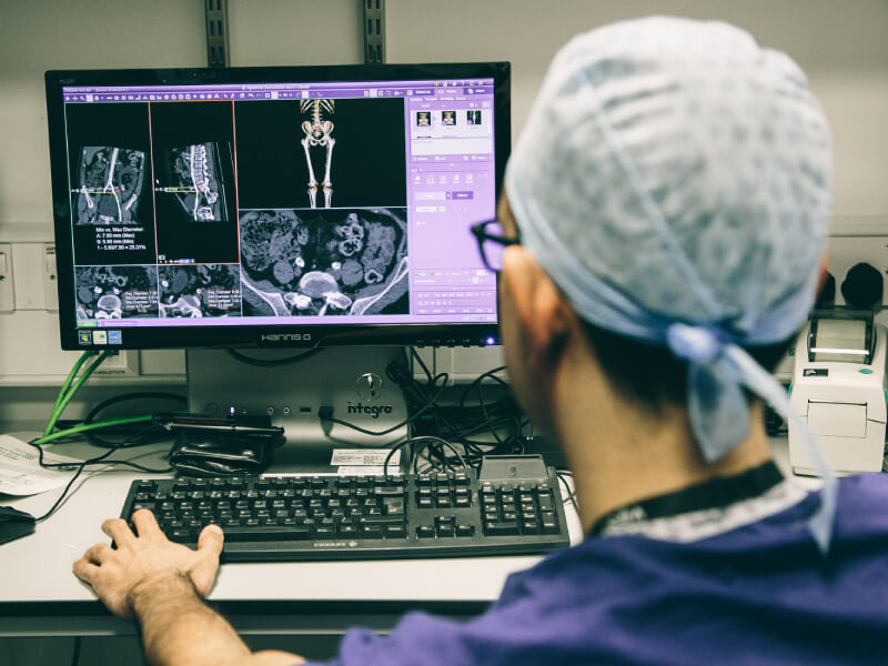 Doctor looking at a computer with a medical scan 