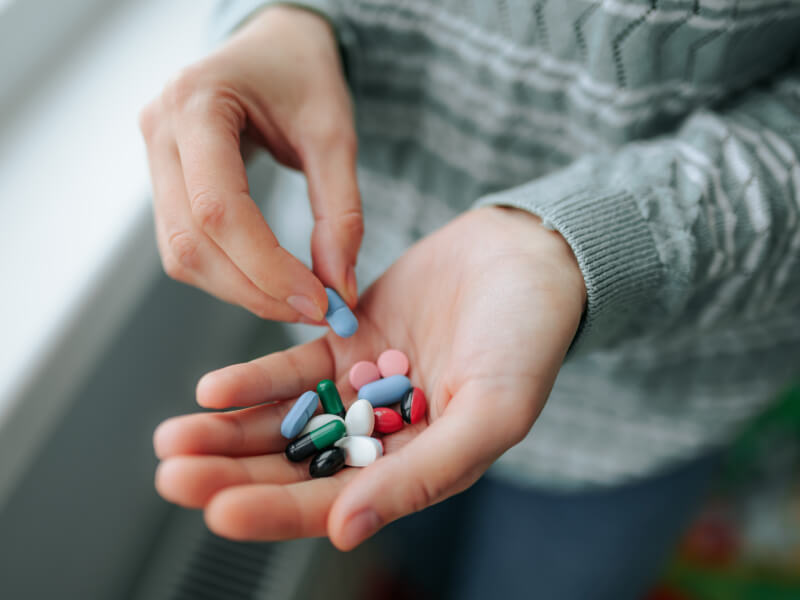 Man holding out his hand to show pills in his palm
