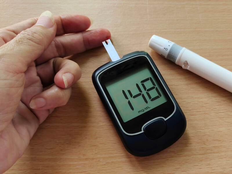 Hand with a cholesterol test kit on a table