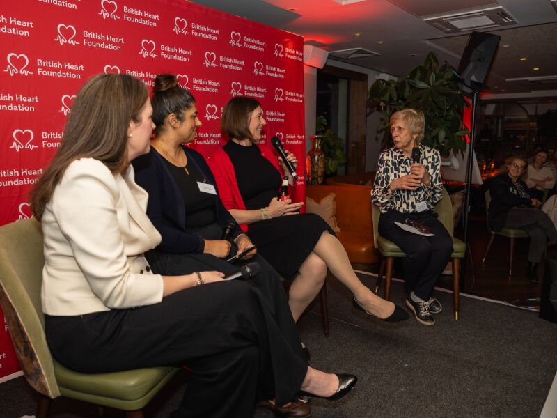 4 women sit on stage for a panel for Women in Science event