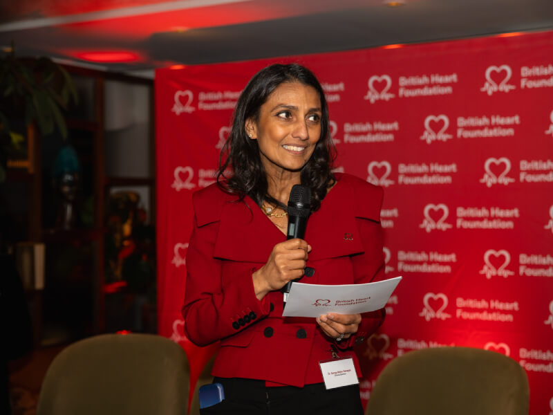 Woman smiles as she delivers a speech at the Women in Science event
