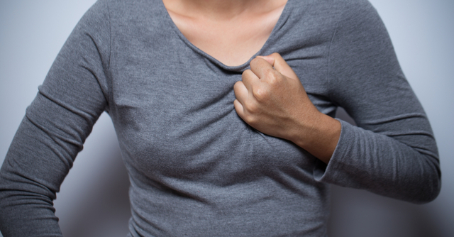 Woman clutching chest, possible heart attack