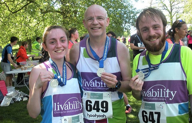 David Swales with his two children in running kit and with medals, after completing a race