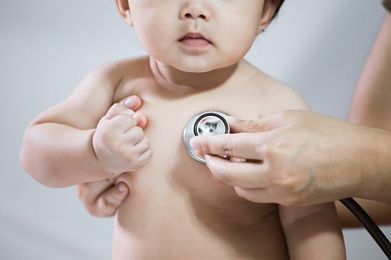 Child with stethoscope listening to its heart