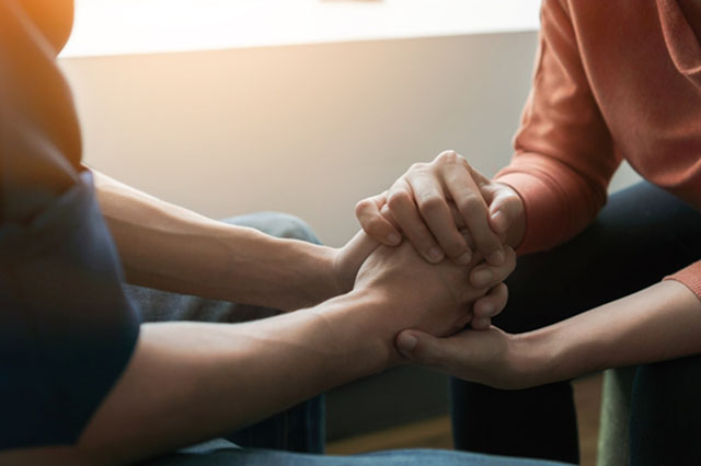 Two pairs of hands holding each other