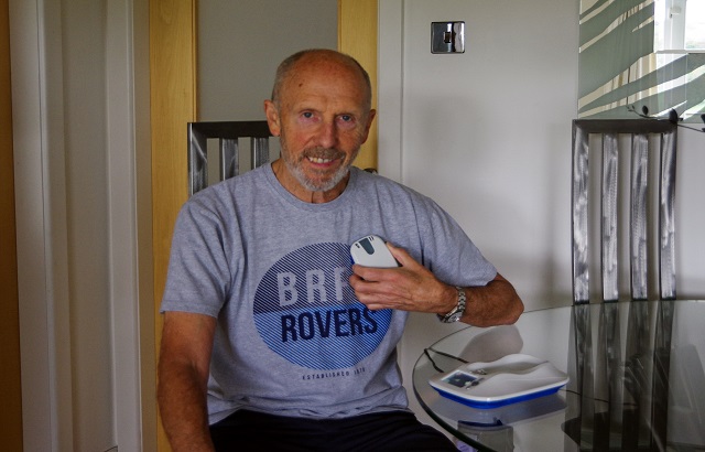 Jim holds a download device next to his chest
