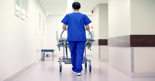 A health and care worker pushing a hospital trolley
