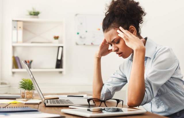Stressed woman with head in hands 