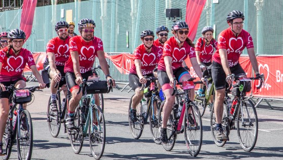 Group of cyclists on their bikes wearing red British Heart Foundation jerseys