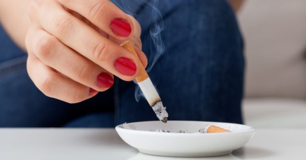 Person putting out cigarette in ashtray