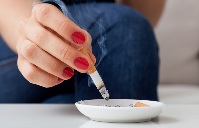 Person putting out cigarette in ashtray