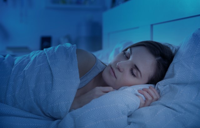Photograph of a woman sleeping in a darkened room