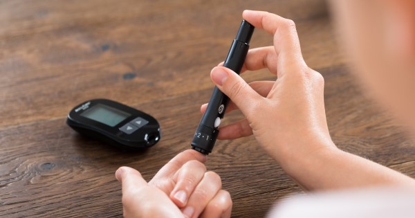 A woman tests her blood sugar by taking a sample of blood from her index finger