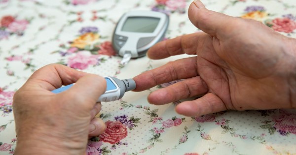 Woman checking her blood sugar levels using a glucometer
