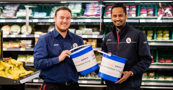 Images of two Tesco staff member in store with collection buckets