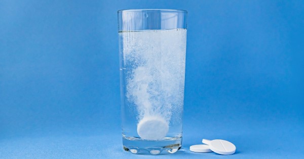 A paracetamol tablet dissolving in a glass of water