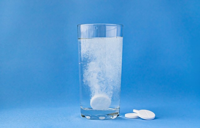 A paracetamol tablet dissolving in a glass of water