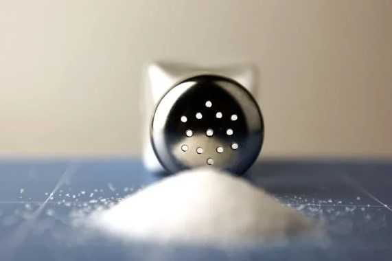 Salt shaker with salt spilling out of it