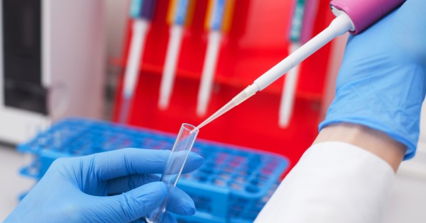A lab worker pipettes into a test tube