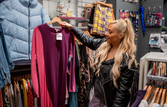 Kimberly Hart-Simpson holding up dress in BHF shop