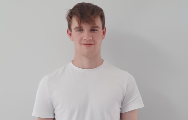 British Heart Foundation volunteer, 17 year old Harry McCaughey, stands against a white background.