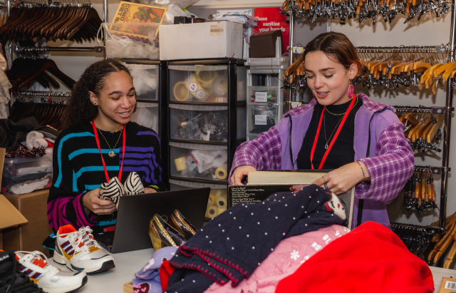 Two students volunteering in a stock room at the British Heart Foundation.