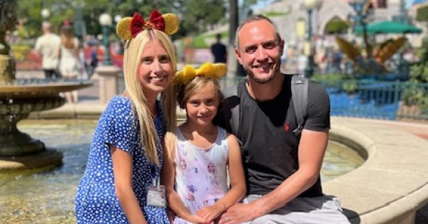 Image of woman, daughter and husband sitting on a fountain 