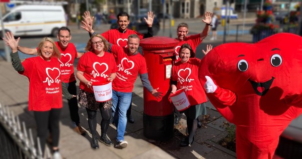 Royal Mail staff and Mr Hearty next to a Royal Mail post box