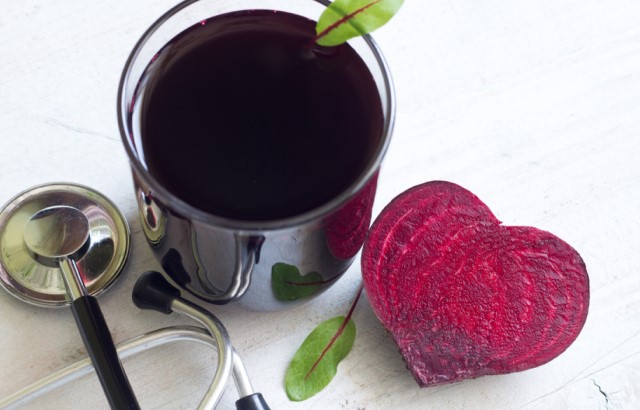 A beetroot, a glass of beetroot juice and a stethoscope