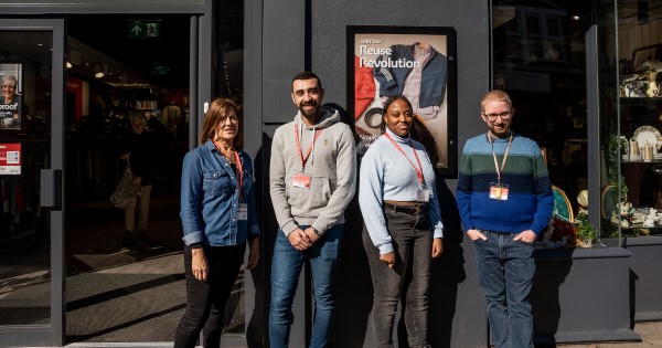 Four volunteers in front of a British Heart Foundation shop.